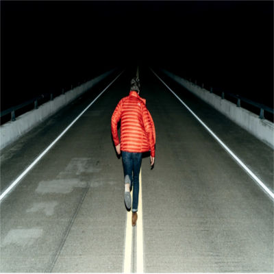 A person running down the middle of a dark road