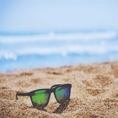 A pair of sunglasses on the beach