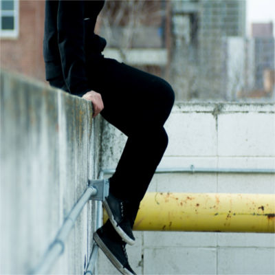 Person sitting on cement wall