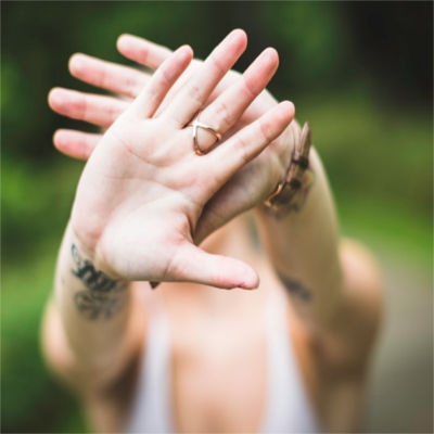 A person putting their hands up to resemble a "stop sign"