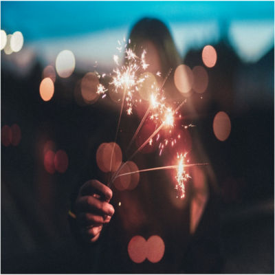 A person holding a lit sparkler