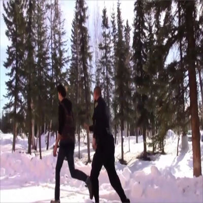 A police officer chasing a person through the woods