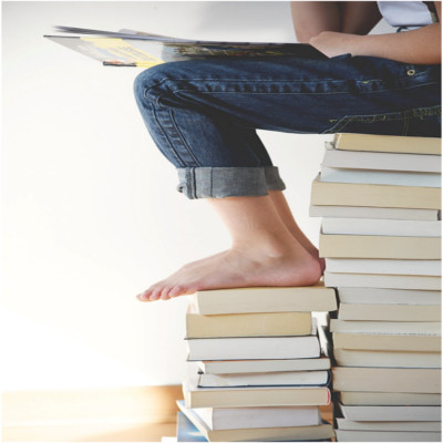 A person sitting on a stack of books